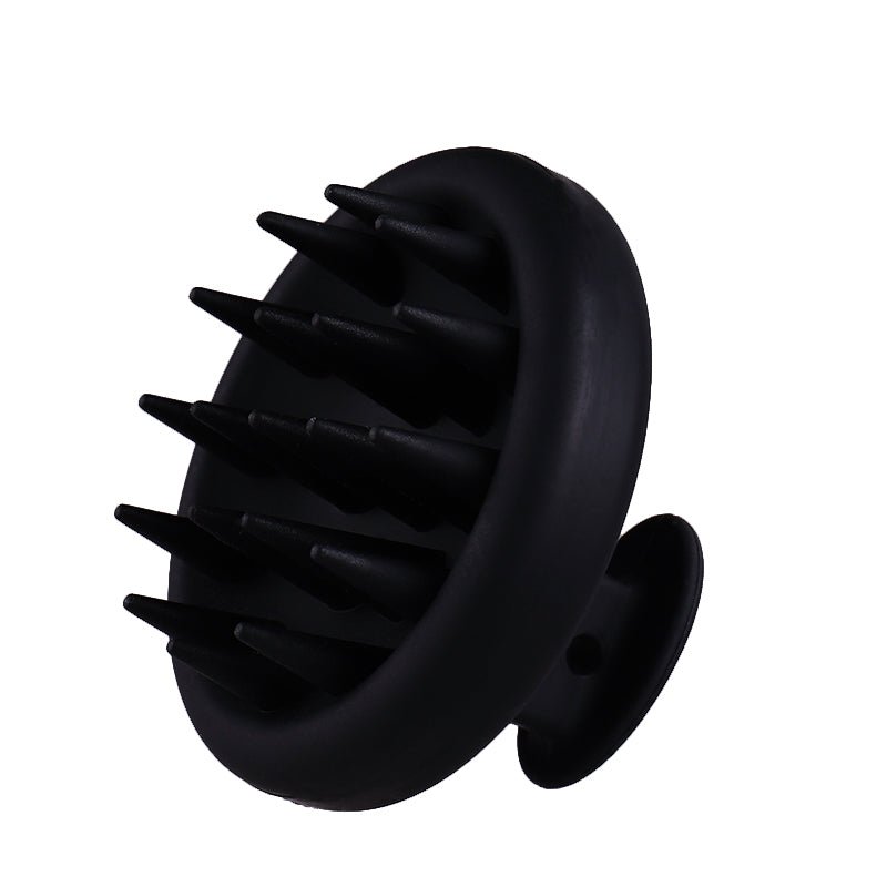 A Gro Scalp Massager Brush by Gro Clinics is a black silicone scalp massager with a circular handle, featuring conical bristles arranged in a circular pattern on its base. It is designed for easy grip and effective scalp stimulation during use, making it an essential hair care tool that exfoliates the scalp effortlessly.