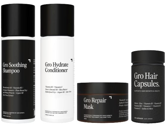 The Ultimate Pack - Hydrate by Gro Clinics includes a variety of hair care products in elegant white and black packaging. This assortment features the Gro Soothing Shampoo, Gro Hydrate Conditioner, and Hair Growth Vitamins. Each product comes with detailed ingredient lists and usage instructions on their labels.