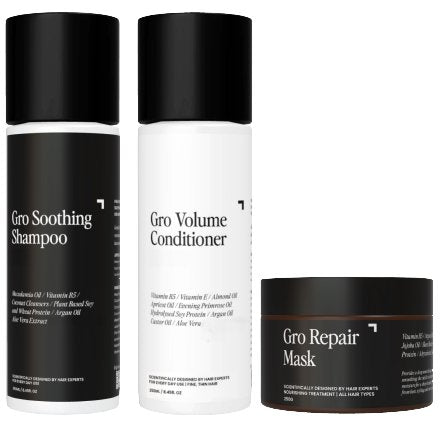 The image showcases three hair care products from Gro Clinics' Hair Health Pack - Volume, elegantly packaged in sleek black and white. From left to right, the products are: Gro Soothing Shampoo, Gro Volume Conditioner, and Gro Hair Repair Mask. Each bottle is adorned with text highlighting the ingredients and benefits.